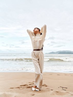 Deniz kıyısındaki dinginlik: Tropik bir plajda güneşli bir günün tadını çıkaran genç ve güzel bir kadın