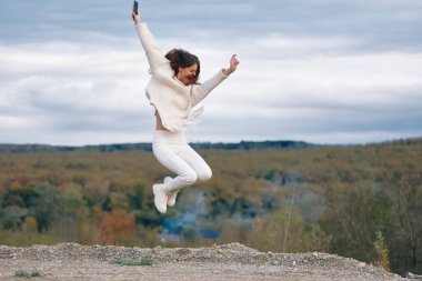 Dağ Telefonu Bağlantısı: Gülümseyen Kadın Doğada Özgürlüğü Kucaklıyor