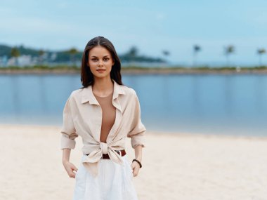 Şık Yaz: Sahilde Mutlu Duygularla Çekici Kadın Pozisyonu, Okyanusa Bakmak ve Beyaz Kum Sahilinde Güneşli Tatilin Tadını Çıkarmak