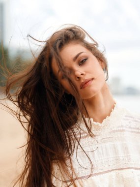 Şehirdeki Güzellik: Çekici Saçlı ve Şık Makyajlı Genç Moda Kadını Sonbahar Güneşi 'nde Rahatlatıcı Yürüyüşün Tadını Çıkarıyor