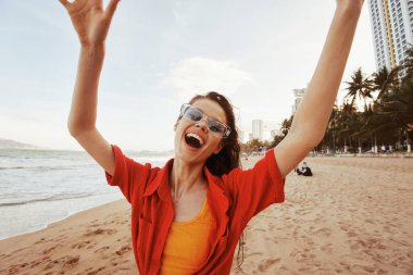 Gülümseyen Kadın, Renkli Günbatımı Sahili 'nde Özgürlük ve Neşe Kucaklayan: Moda Moda Modeli, Okyanus Tatilinin Keyifli Seyircisi