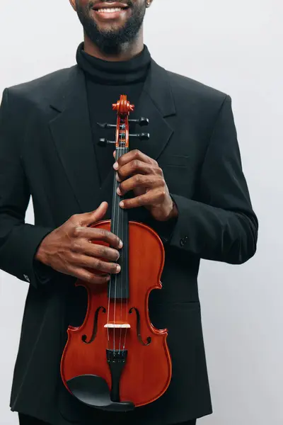 身穿黑色高领毛衣 身穿夹克 手持小提琴 姿势优雅的非裔美国人 — 图库照片