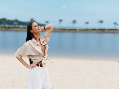 Sahilde Güzel Yaz Tatili 'nin tadını çıkaran, Mavi Okyanus ve Beyaz Kum' la Güneşli Açık Hava 'da Neşeli ve Kaygısız görünen Kadın.