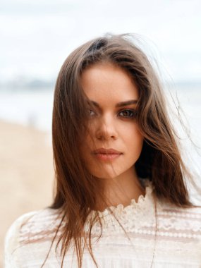 Çekici Gülümseyen Güzel Kadın Modeli: Esmer Kıvırcık saçlı, Arkaplanda Genç Bir Kadının Beyaz Yaz Portresi