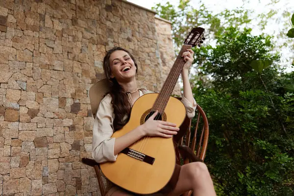 Жінка Сидить Стільці Акустичною Гітарою Перед Кам Яною Стіною Стокова Картинка