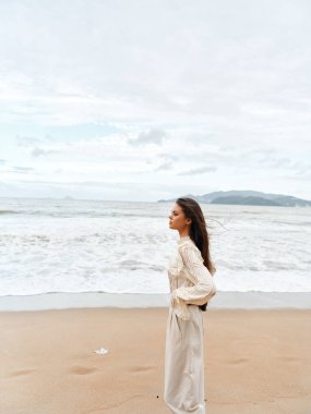 Huzurlu Yalnızlık: Genç, Çekici Kafkasyalı Bir Kadın Gün Doğarken Tropikal Sahilde Özgürlük ve Gevşemeyi Kucaklıyor