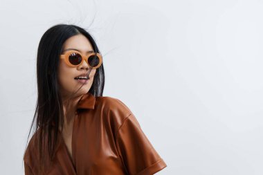 Güzel bir kadın moda saçı güneş gözlüğü cazibeli bej model tatiller Asyalı yaşam tarzı portresi