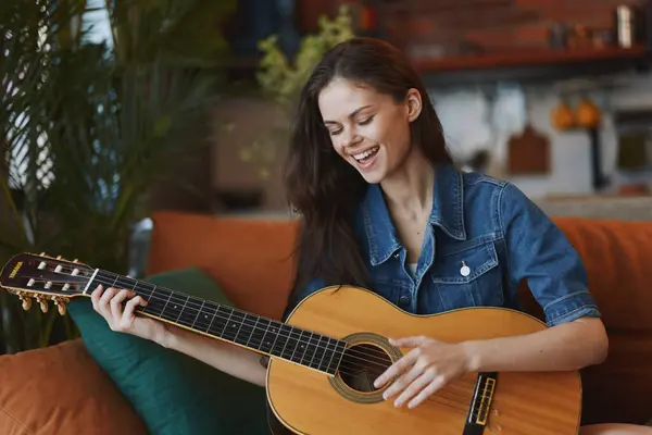 Mulher Tocando Guitarra Acústica Sofá Frente Parede Verde Ambiente Acolhedor — Fotografia de Stock