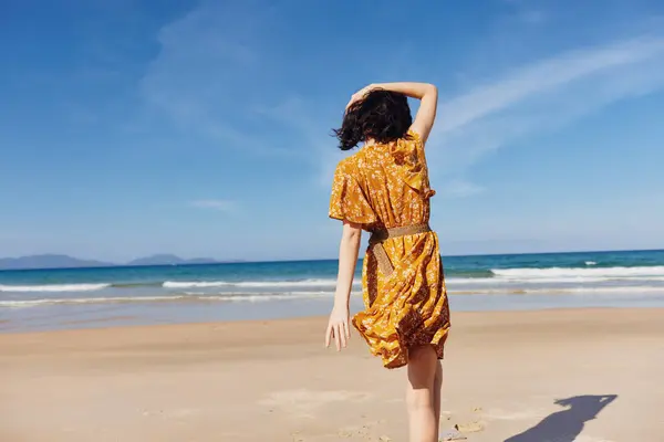Mujer Vestido Amarillo Pie Playa Con Vuelta Océano Disfrutando Momento — Foto de Stock