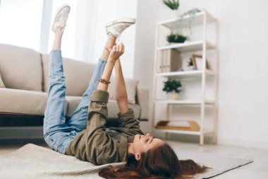 Modern apartmandaki rahat koltukta dinlenen mutlu kadın.