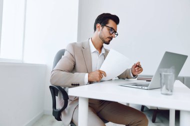 Yakışıklı takım elbise lideri dizüstü bilgisayar başarısı iletişimi kuruyor. Pozitif beyaz belge iş adamı kağıt şirketi gülümsüyor. İş yeri yaşam tarzı mutlu konsept gözlükleri profesyonel.
