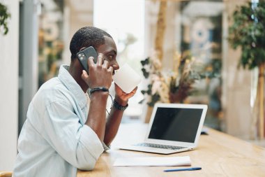 Erkek telefon uzmanı yetişkin girişimci erkek iletişimi dizüstü bilgisayarda çalışan iş adamı masa başı bilgisayar işi genç teknoloji konuşuyor