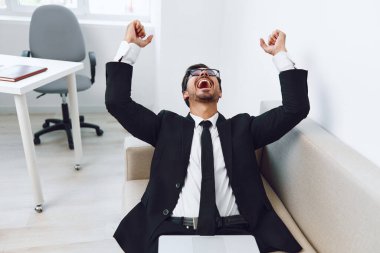 Erkek kanepe, başarılı bir yetişkin ağı kurmak ev yapımı video dizüstü bilgisayarı çevrimiçi girişimci erkek iş dünyası kanepe iletişim gözlükleri kapalı alanda gülümseyen yakışıklı gözlük.