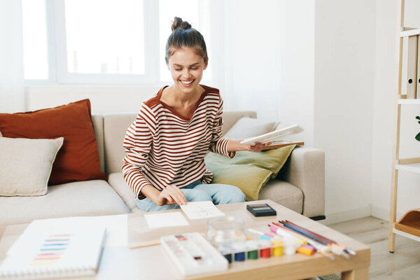 Creative Teenage Girl Painting at Home: Happy Hobbyist Artist Enjoying Artwork on Sofa