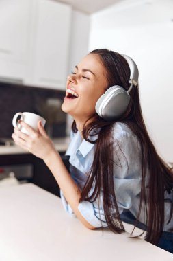 Genç bir kadın, rahat bir kafede kahve ve müzikten zevk alıyor.