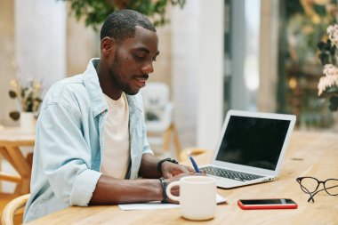 Profesyonel adam modern ofis erkeği çevrimiçi bilgisayar girişimcisi genç not defteri oturan iş adamı iş yeri teknoloji dizüstü bilgisayarı yazarı.