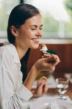 Mutlu Kadın Evde Romantik Yemeği Zevk Alırken, Lezzetli Yemeği Şımartırken ve Ekstaziyle Gülümserken Yemek Masası Moda ve Şık Dekorla Ayarlandı, Ev Yapımı Pasta ve Şarap Bardağıyla