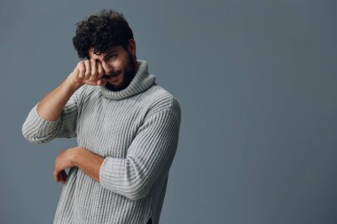 Sakallı adam mutsuz genç yetişkin yüz ifadesi erkek moda süveteri beyaz arka plan yakışıklı erkek portresi yakışıklı havalı stüdyo mankeni yalnız duran beyaz adam.