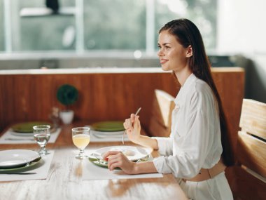 Mutlu Gülümseyen Kadın, Moda ve Şık Yemek Odası 'nda Ev Yapımı Yemek, Pasta ve Şarap Tarifi ile Romantik Yemeğin keyfini çıkarıyor Bu büyüleyici ve şık yemek odasında,