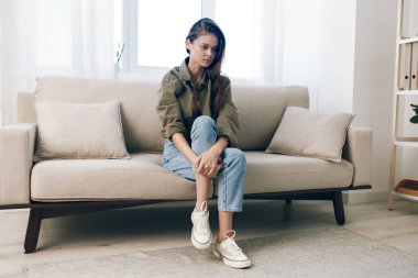 Üzgün ve Endişeli Kadın Bir Koltukta Otururken Evde Umutsuzluk ve Ruh Sağlığı Krizi İfade Ediyor