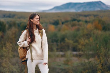 Dağ Macerası: Gülümseyen Kadın Uçurumda, Doğanın ve Özgürlüğün tadını çıkartıyor
