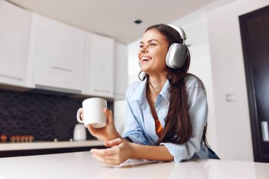 Kahve ve müzikten hoşlanan bir kadın kulaklıkları açık, rahat ve rahatlatıcı bir atmosferde.