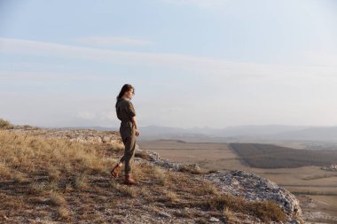Vadiyi ve dağları gören tepede duran kadın çarpıcı doğa manzarası ve seyahat eden güzellik.