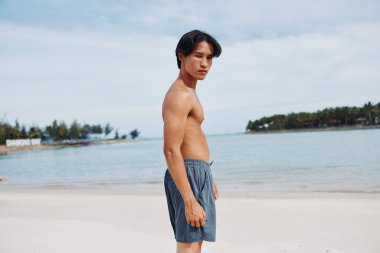 Sahilde Egzersiz Yapan Aktif Asyalı Adam: Kumda Kas Sporu