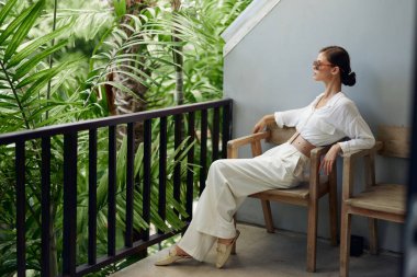 Gülümseyen Kadın Balkon Terasında Tropikal Tatilin Tadını Çıkarırken Elinde Ferahlatıcı Bir İçecekle