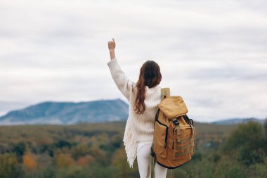 Yürüyüşçüler: Gülümseyen Kadın Doğada Maceranın tadını çıkarıyor, Bir Dağ Uçurumuna Tırmanıyor