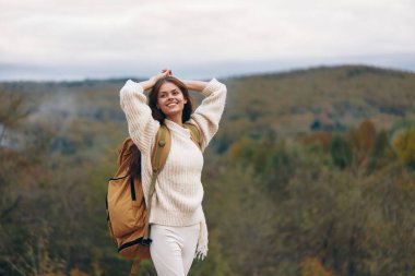 Gülümseyen Kadın Dağ Macerasını Kucaklıyor: Mutluluk ve Özgürlüğün Şık Yolculuğu