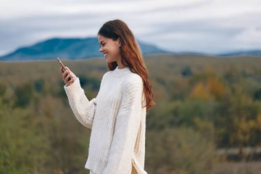 Dağ Kadını: Gülümseyen Maceracı Gezgin Doğayı Telefonla Yakalıyor.