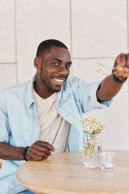 Yaşam tarzı özgüveni olan bir adam siyah, neşeli, soyutlanmış bir gülümsemeyle mutlu bir ifadeyle Afrikalı bir erkekle yetişkin bir Amerikan portresiyle yüzleşir.