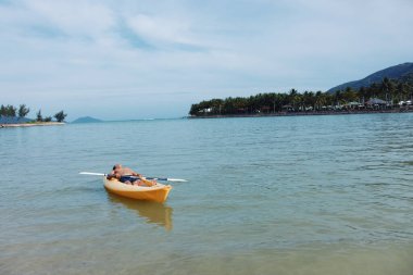 Keyifli Kano Macerası: Tropik Plajda Yaz Tatili Yapan Mutlu Asyalı Bir Adam