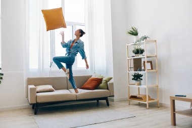 Neşeli Kadın Neşeli Zıplıyor ve Müzikle Dans Ediyor Mutlu, Neşeli bir Konsept, Evdeki Koltukta Rahatlıyor