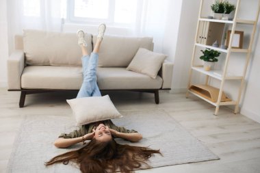 Sakin ve rahat bir kadın huzurlu dairesinde modern bir kanepede dinleniyor..