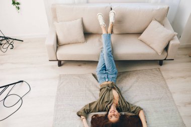 Ev Rahatlığı: Gülümseyen bir kadın Modern bir apartmanda rahat bir koltukta dinleniyor