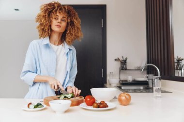 Afro-Amerikalı kadın mutfağında sağlıklı yemekler pişiriyor, taze malzemelerle besleyici yemekler hazırlıyor.