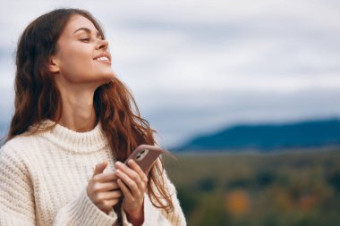 Telefondaki Dağ Kadını, Özgürlük ve Doğa 'yı Saran Yaşam Tarzı: Macera Yolculuğunda Turist Gülümsemesi, Siber Uzay Bağlantı Yolculuğunda Selfie takıntılı Gezginle Yürüyüş.