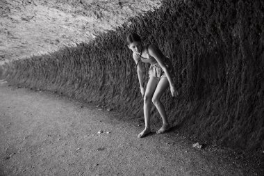 SağIık terapisi sırasında taş duvarın önünde yoga yapan bir kadın.