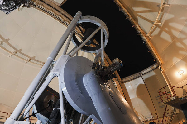 A large telescope gleams inside a majestic observatory, ready to uncover the mysteries of the cosmos.