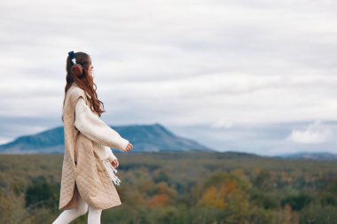 Melodik Dağ Mutluluğu: İlkbahar Macerası Ortasında Doğaya Dans Eden Neşeli Bir Kadın