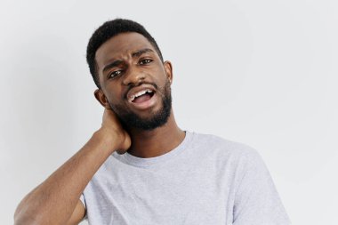 Düşünceli genç bir adam, eli başının üstünde, içe dönük bir ifadeyle yukarıya bakıyor, hayatla ilgili kararları düşünüyor..