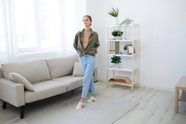 Neşeli Zıplama: Rahatlatıcı bir Apartmanda Dans Eden Neşeli Bir Bayan Bir Gülücük ve Bir Kanepede Müzik