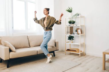 Neşeli Zıplama: Mutlu Bir Kadın Dans Ediyor ve Tasasız Evinde Şarkı Söylüyor