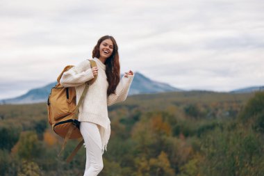 Dağ Macerası: Gülümseyen Kadın Uçurumda Sırt Sırtında, Doğayı Saran Özgürlük ve Tırmanan Yolculuk