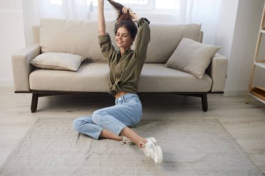 Modern bir dairede rahat bir koltukta dinlenen mutlu kadın.