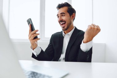 Ofis işadamı masasında oturuyor ve dizüstü bilgisayarda çalışıyor ve telefonla konuşuyor, modern takım elbise, finans ve başlangıç konsepti ve veri analizi, parlak bir ofiste çalışma tarzı. Yüksek kalite fotoğraf