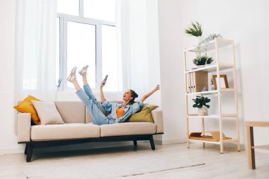 Modern Salon 'da rahat koltukta gülümseyen kadın cep telefonunu tutuyor.