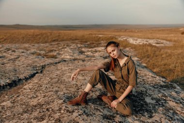 Tarlaların ortasında sakin bir anın tadını çıkaran bir kadın. Elleri kalçasında seyahat ve doğa düzeninde.